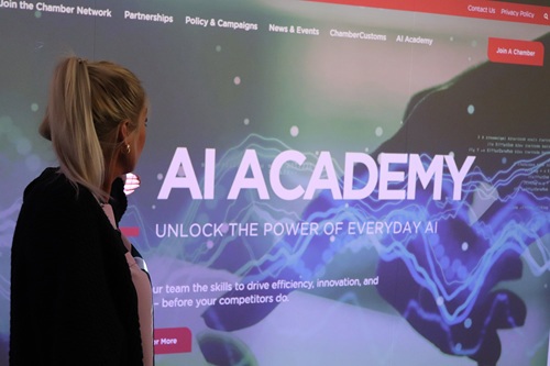 Woman standing in front of screen with text on